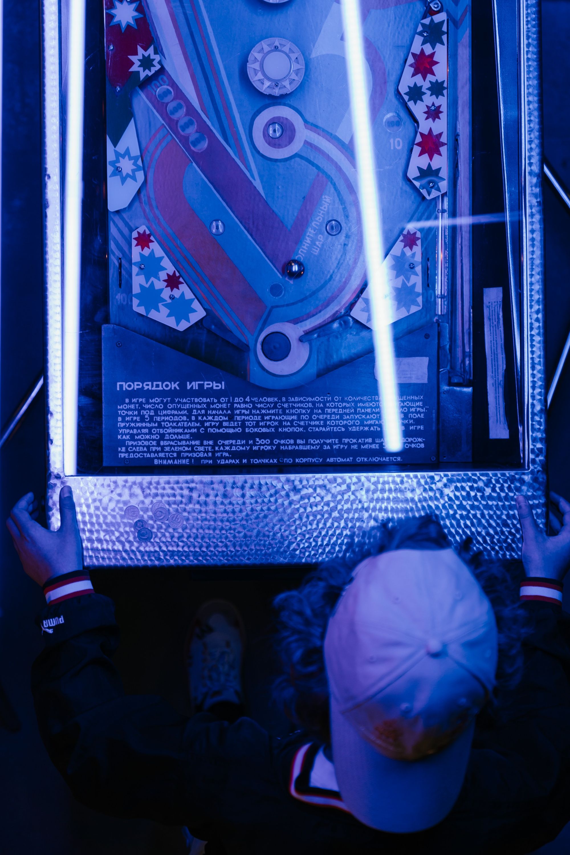 Teenager playing a pinball arcade game