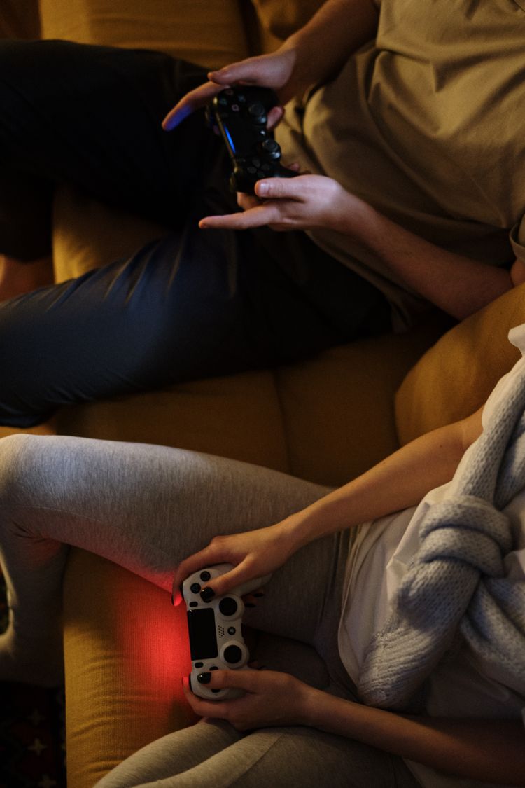 A couple sitting on the couch playing video games