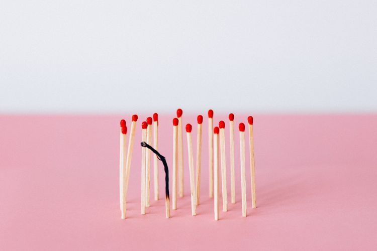 Image of matchsticks, with only one match burnt out completely